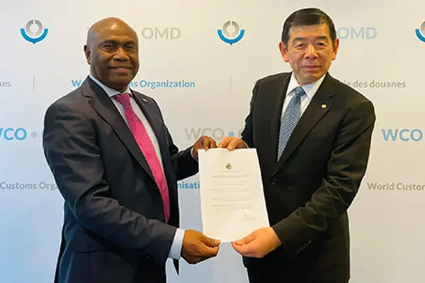 Ambassador Mose and WCO Secretary-General Dr. Kunio Mikuriya showing membership certificate.