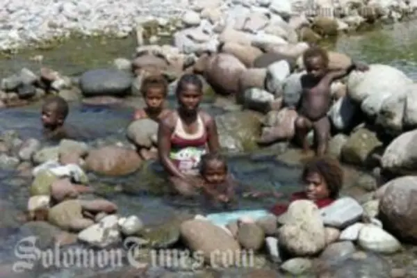Women and children in a makeshift bath on Guadalacanal.