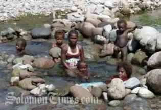 Women and children in a makeshift bath on Guadalacanal.