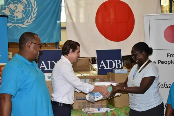 Mr. Elmar Elbling, Unit Head Solomon Islands Pacific Country Office, ADB, handing over some of the  PPEs to MHMS Permanent Secretary Mrs. Pauline McNeil in front of Chief of UNICEF Solomon Islands Office, Dr. Zelalem Taffesse.