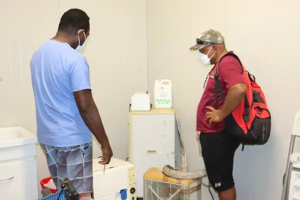 Nila ACH Manager Moses Lamana (left) and NRH Biomedical Engineer Douglas Rerese (right) looking at the Benchtop Sterilizer.