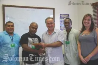 Jeddy Dyer receives his ticket and schedule from the Australian High Commissioner, H.E Frank Ingruber.