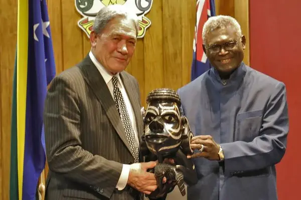 Solomon Islands Prime Minister Manasseh Sogavare presents a Nguzu Nguzu to New Zealand's Deputy Prime Minister Winston Peters.
