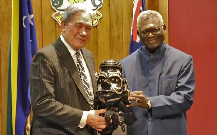 Solomon Islands Prime Minister Manasseh Sogavare presents a Nguzu Nguzu to New Zealand's Deputy Prime Minister Winston Peters.