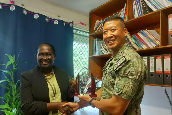 Capt. Henry Kim Commander of the Pacific Partnership Mission presenting gift to the Ministry of Health and received by Health Permanent Secretary, Mrs Pauline McNeil.