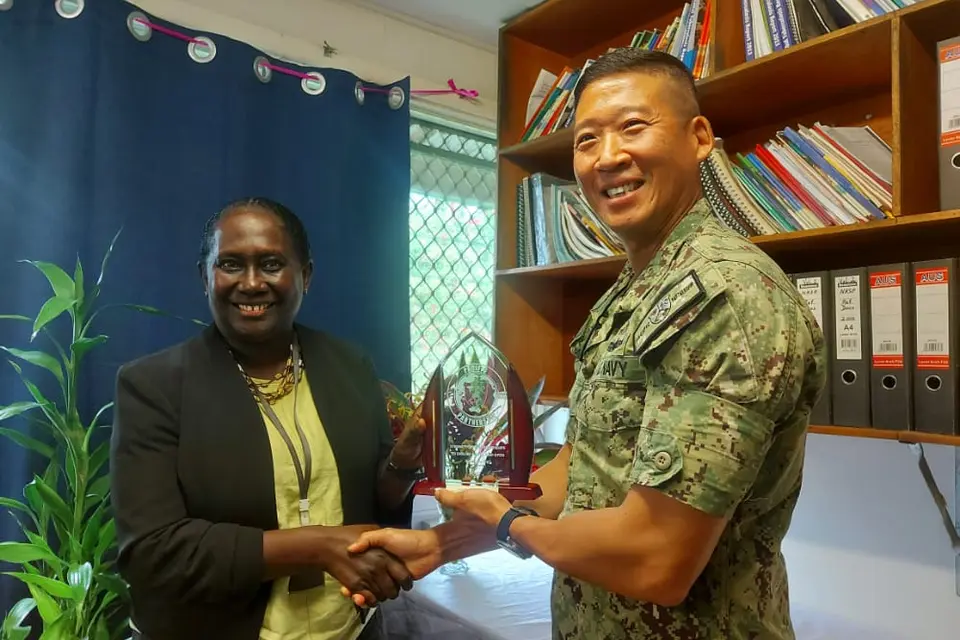 Capt. Henry Kim Commander of the Pacific Partnership Mission presenting gift to the Ministry of Health and received by Health Permanent Secretary, Mrs Pauline McNeil.