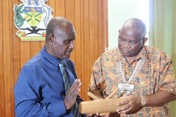 Minister of Foreign Affairs and External Trade, Hon. Jeremiah Manele presenting a gift to the Secretary General of the Secretariat of the Organization of African, Caribbean and Pacific States (OACPS), H.E Dr Georges Rebelo Pinto Chikoti.