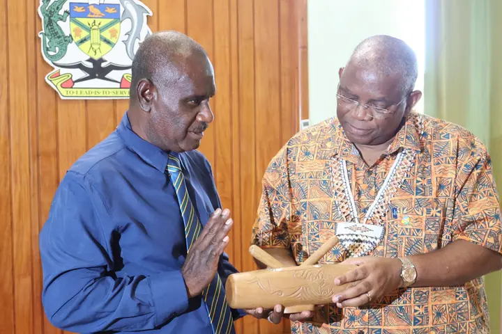 Minister of Foreign Affairs and External Trade, Hon. Jeremiah Manele presenting a gift to the Secretary General of the Secretariat of the Organization of African, Caribbean and Pacific States (OACPS), H.E Dr Georges Rebelo Pinto Chikoti.