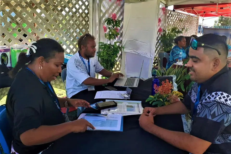 Strongim Bisnis Senior Business Advisor James McGoon at a booth talking with one of the 28 tourism operators.