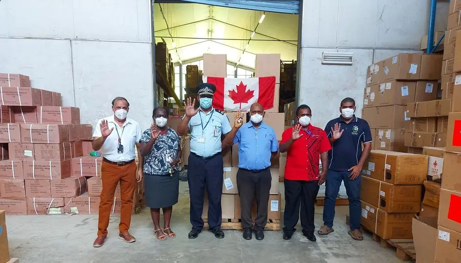 Group photo with consignment of face masks. L-R Dr Yogesh Choudhri MHMS Senior Advisor, Mrs. Pauline McNeil, MHMS Permanent Secretary, Mr. Mostyn Mangau Police Commissioner, Hon. Dr Culwick Togamana Health Minister, Cornelius Walegera Deputy Secretary Foreign Affairs and Wesley Kukutu Manager National Medical Store.