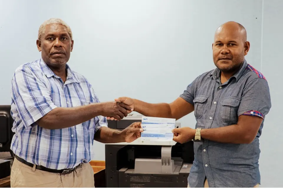 Central Guadalcanal Constituency Officer, Mr. Philip Naisa hands over the cheques to Constituency School fee Coordinator Joe Frazer.