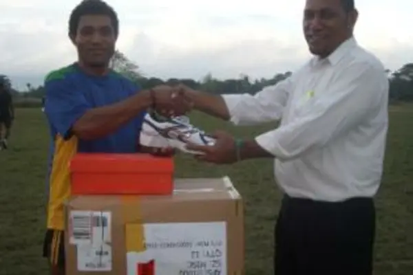 Rugby 7s coach Jim Seuika (r) handing over the sporting equipment to the 7s captain Edmond Tay.