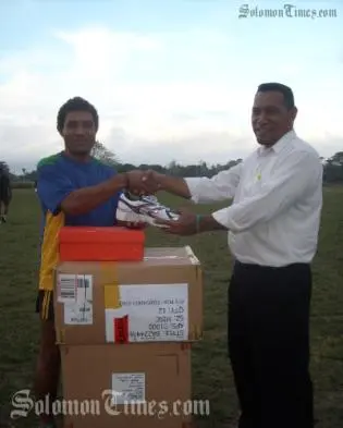 Rugby 7s coach Jim Seuika (r) handing over the sporting equipment to the 7s captain Edmond Tay.