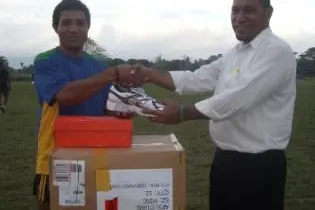 Rugby 7s coach Jim Seuika (r) handing over the sporting equipment to the 7s captain Edmond Tay.