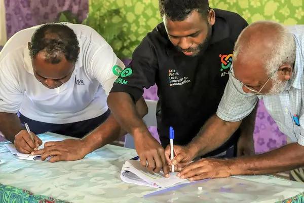 The signing of the partnership between Kastom Garden Association (KGA) and Oxfam is part of the Australian Humanitarian Partnership (AHP) COVID-19 response. Pictured are Oxfam Solomon Islands Country Coordinator Richard Sakiri (left), Oxfam Humanitarian Coordinator Nicholas Suava (centre) and KGA Chairman Frank Tabai.