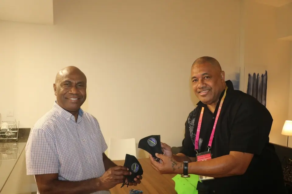 Commissioner General Ambassador, Moses Kouni Mose and Communications Volunteer, Mr. Kelepi Abariga display customized Solomon Islands face masks at the Solomon Islands Pavilion.