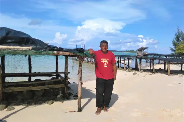 Mr Ata standing beside his table on the island of Peniamina, just outside of Wagina.