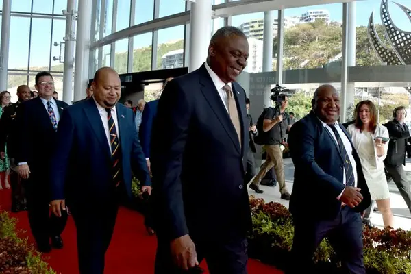 Papua New Guinea’s Defence Minister Win Bakri Daki (R) and U.S. Secretary of Defense Lloyd Austin (C) walk to their meeting in Port Moresby on July 27, 2023.