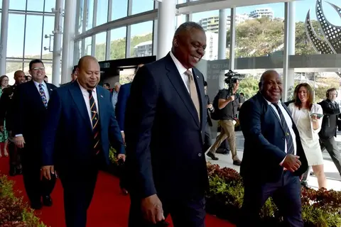 Papua New Guinea’s Defence Minister Win Bakri Daki (R) and U.S. Secretary of Defense Lloyd Austin (C) walk to their meeting in Port Moresby on July 27, 2023.