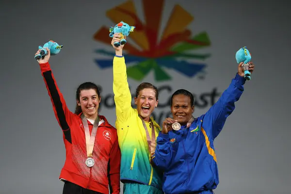 Jenly Wini (far right) is the woman behind Solomon Islands’ success, lifting the country to victory in the 58 kilogram weight division earlier in the games.