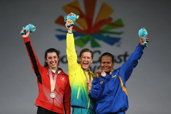 Jenly Wini (far right) is the woman behind Solomon Islands’ success, lifting the country to victory in the 58 kilogram weight division earlier in the games.