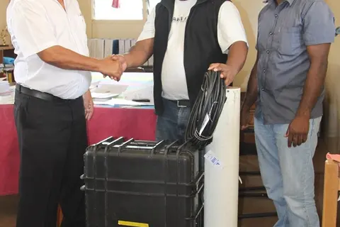 General Manager of SIBC, Ashley Wickham (Left) receiving the mobile radio unit from Lawrence Hillary and Jeremiah Tabua of World Vision.
