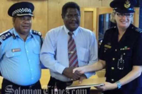 Acting Police Commissioner, Walter Kola, Hon. James Tora and Wing Commander, Wendy Horder handing over the letter of arrangements.