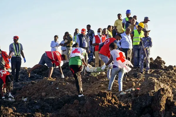 Rescue workers at the site of Ethiopia Airlines Flight 302 crash on Sunday, where more than 150 people were killed.