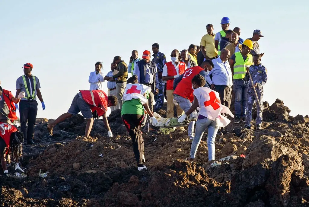 Rescue workers at the site of Ethiopia Airlines Flight 302 crash on Sunday, where more than 150 people were killed.