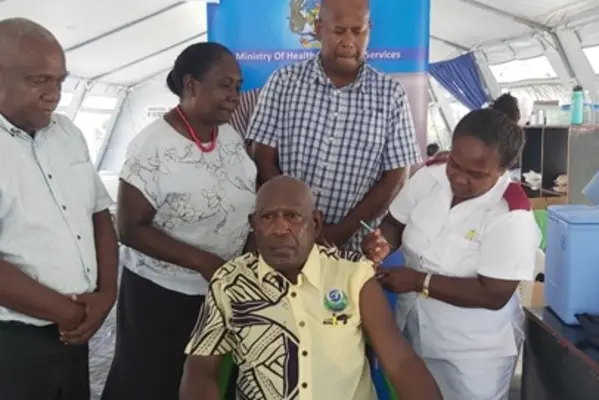 Supervising Premier Hon. Isaac Tatapu ready to receive his vaccination with which was witnessed by (back row from left) MHMS Director Planning Mr. Ivan Ghemu, Health PS Mrs Pauline McNeil and Western Provincial Health Director Dr Dickson Boara.